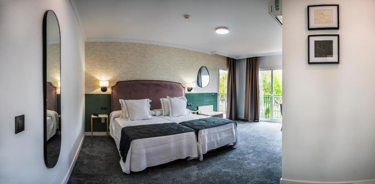 Un dormitorio con una cama grande en una habitación. en Hotel Tamisa Golf, en Mijas