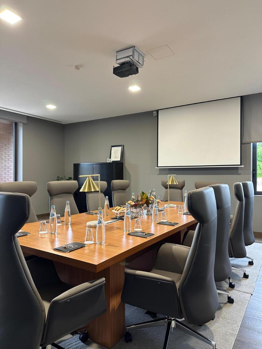 uma sala de conferências com uma grande mesa de madeira e cadeiras em DS Hotel Lusopark em Santa Maria da Feira mais 107 fotografias