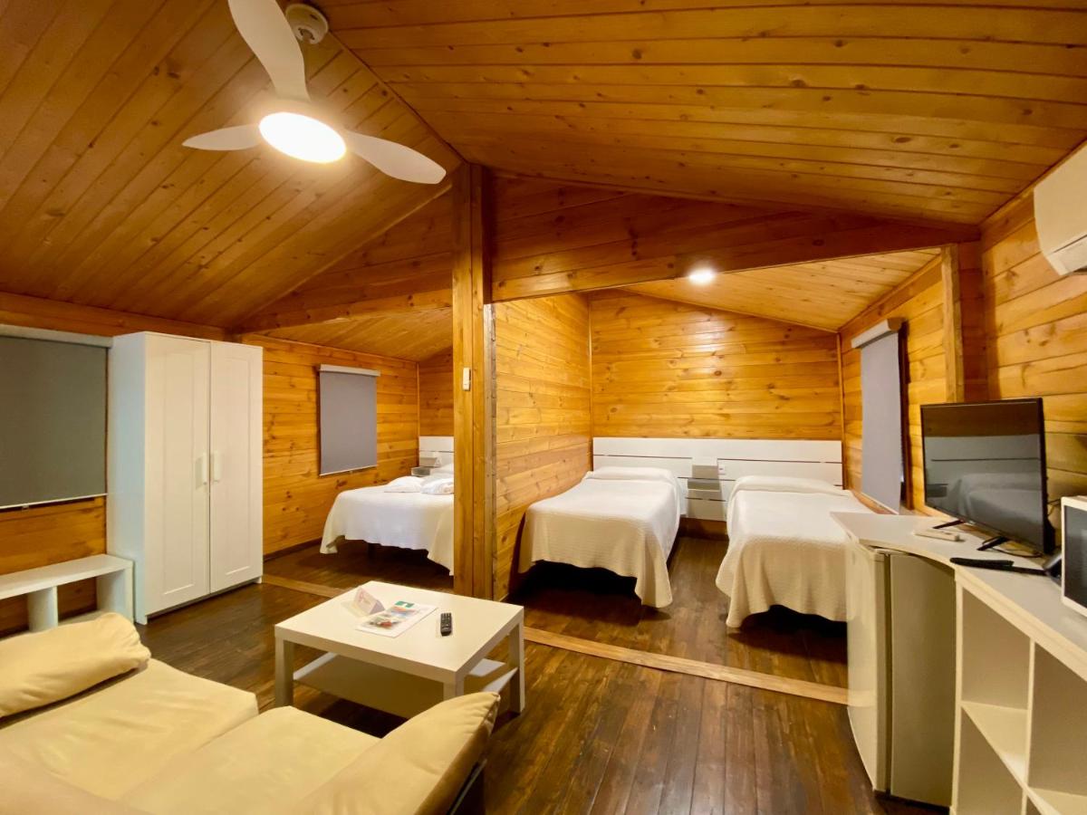 Una habitación con tres camas y un televisor. en Balneario San Andres, en Canena
