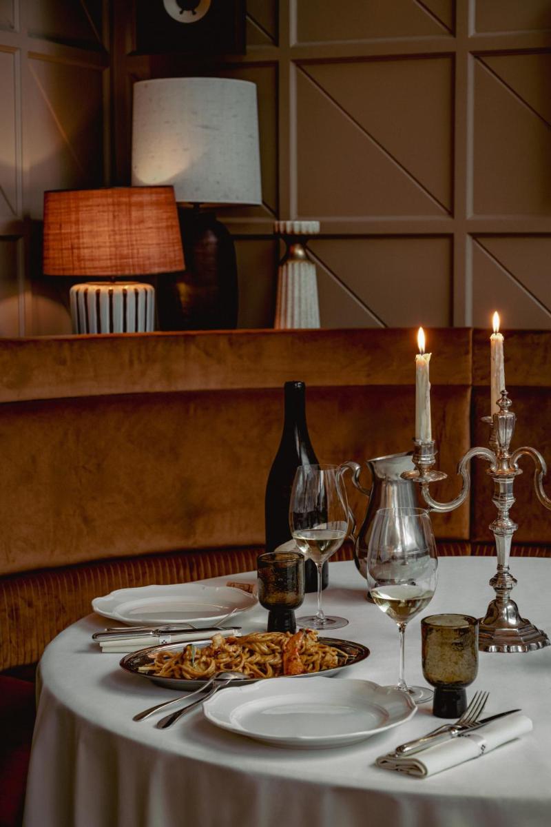 - une table avec une assiette de pâtes et des verres à vin dans l'établissement Experimental Marais, à Paris