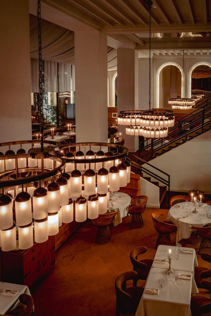 une salle à manger avec des tables et des lustres dans l'établissement Experimental Marais, à Paris