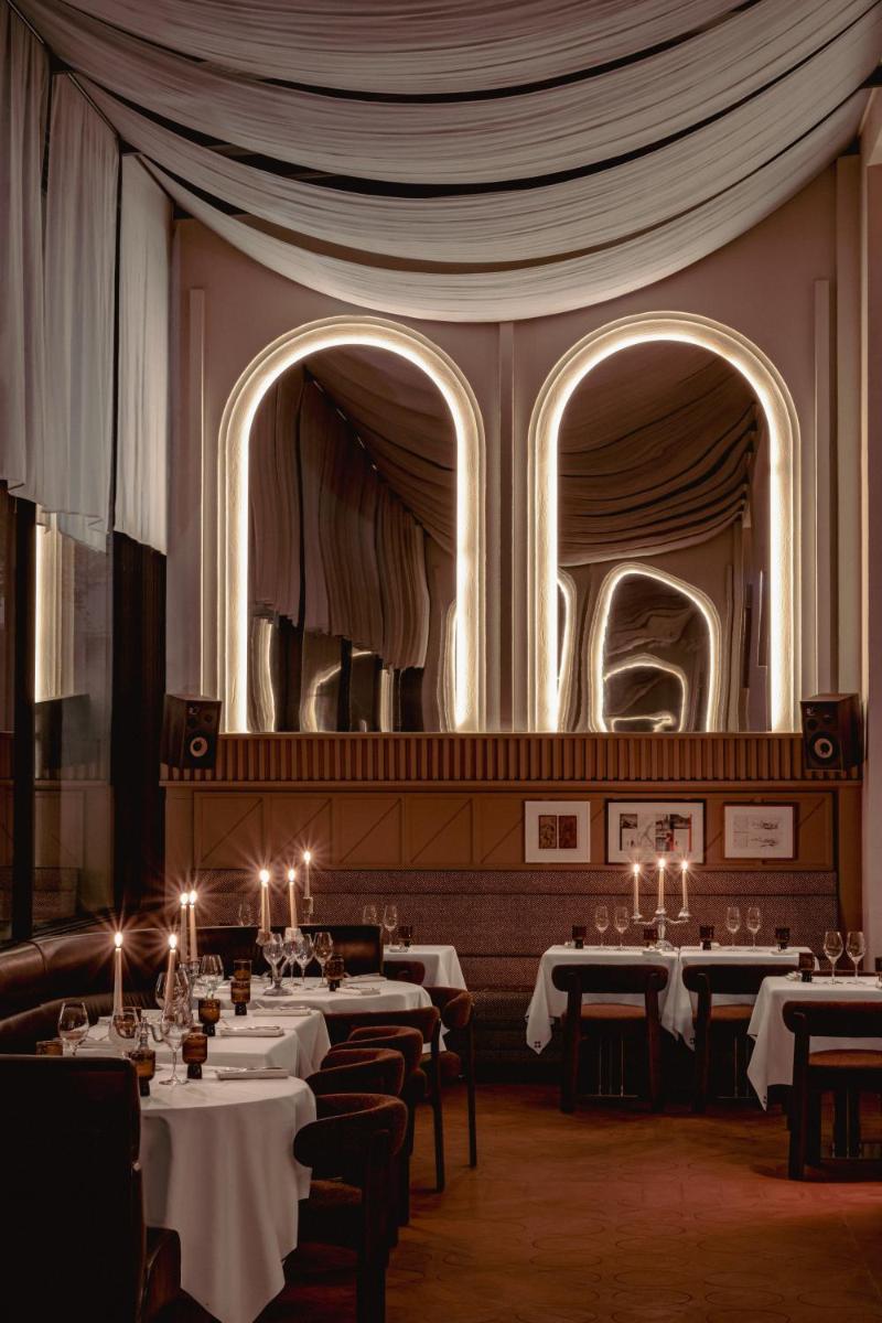 une salle à manger avec des tables et un grand miroir dans l'établissement Experimental Marais, à Paris