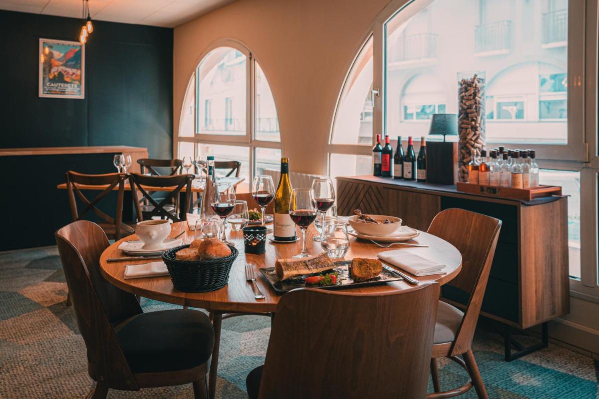 - une table avec des verres à vin et de la nourriture dans l'établissement Garden & City Cauterets Balneo, à Cauterets