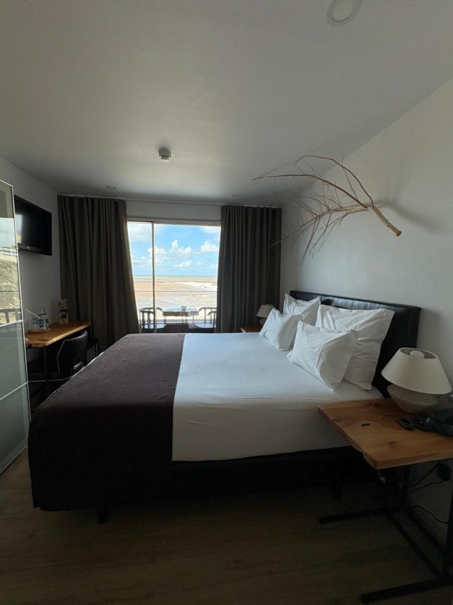 um quarto com uma cama grande com vista para o oceano em Promar - Eco Beach & Spa Hotel em Maceira