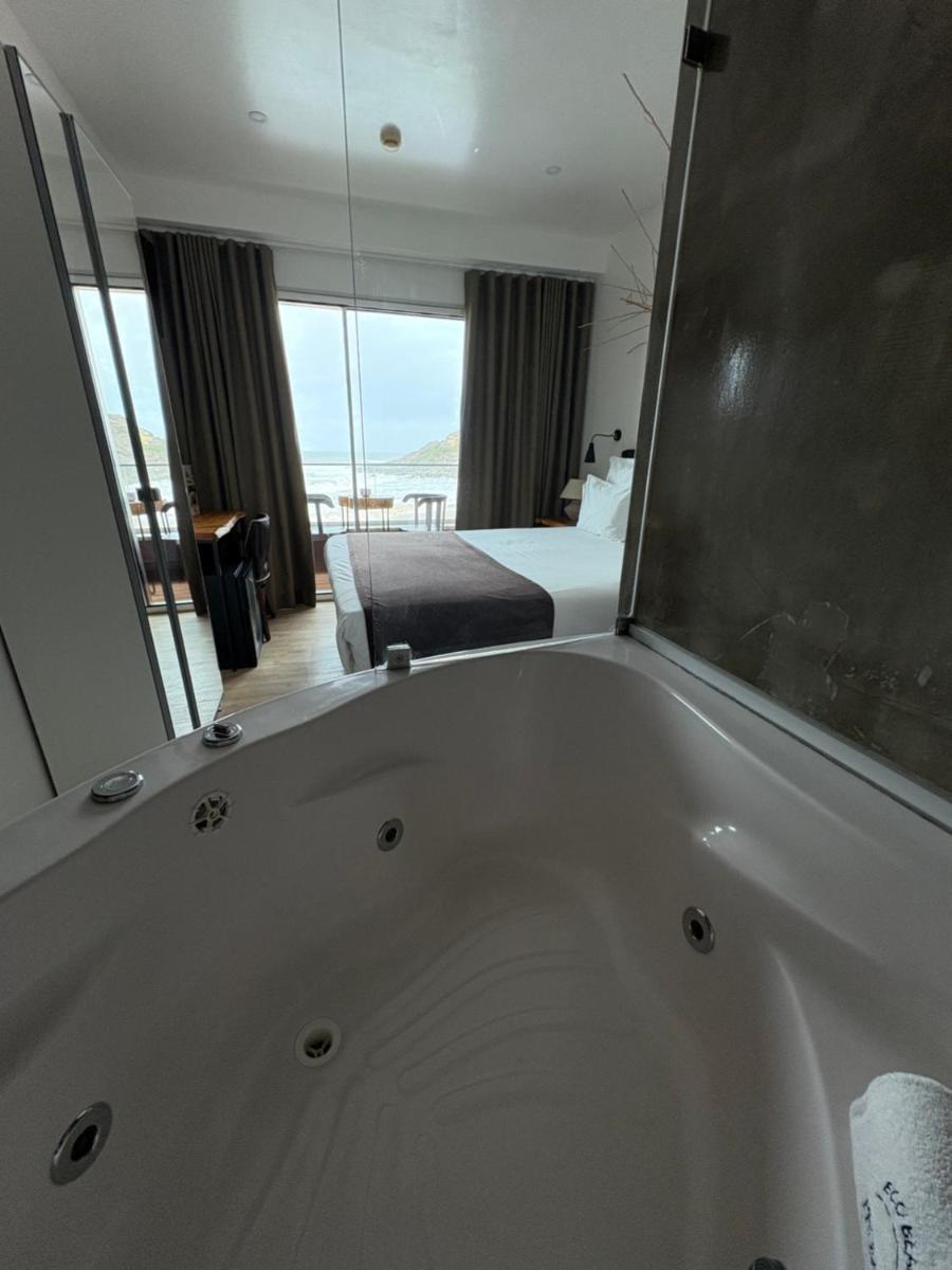 uma casa de banho com uma banheira com uma cama e um quarto em Promar - Eco Beach & Spa Hotel em Maceira