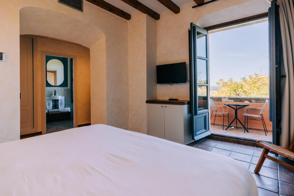 Un dormitorio con una cama grande y un balcón. en Gran Claustre Boutique Hotel, en Altafulla 74 fotos más