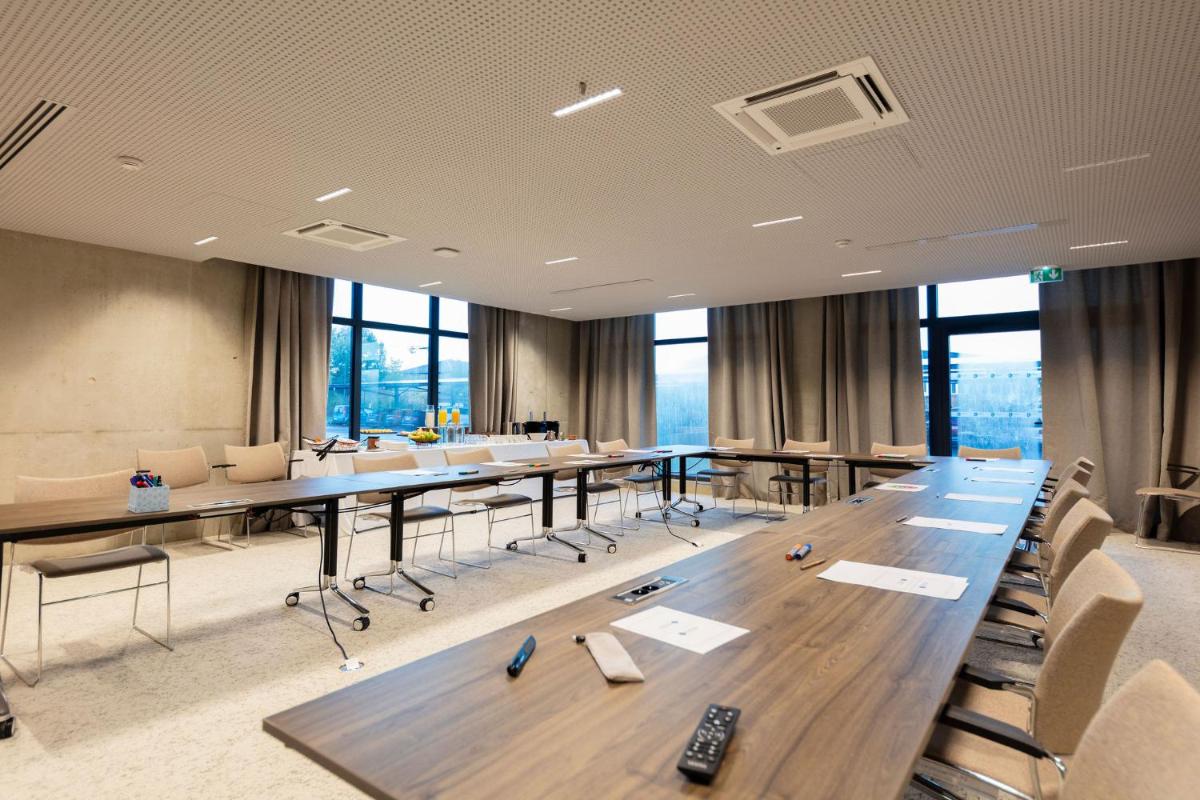 une salle de conférence avec une longue table et des chaises dans l'établissement Ki Space Hotel & Spa - near Disneyland Paris, à Serris 90 autres photos