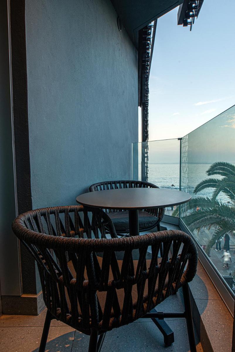 una mesa y una silla en un balcón con vistas al océano en Silken Saaj Maar - Adults Only, en Puerto de la Cruz