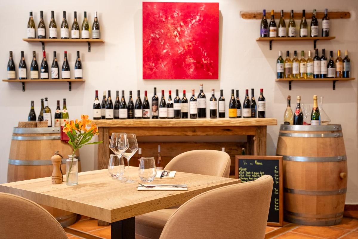 - une table dans une salle de dégustation de vins avec des bouteilles de vin dans l'établissement Hôtel Restaurant & Spa La Maison Oppoca, à Ainhoa