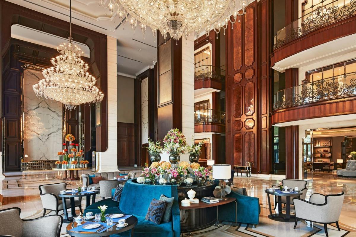 a lobby with tables and chairs and a chandelier at The Ritz-Carlton, Pune in Pune