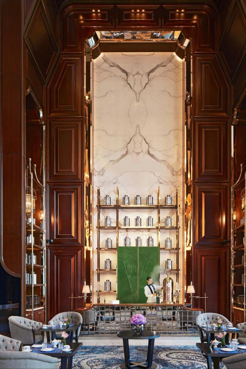 a man standing at a screen in a room with a wall at The Ritz-Carlton, Pune in Pune