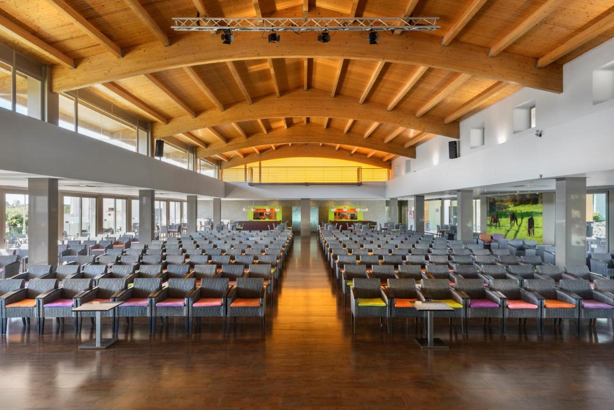 un salón vacío con sillas y un techo grande en Occidental Menorca, en Punta Prima 37 fotos más