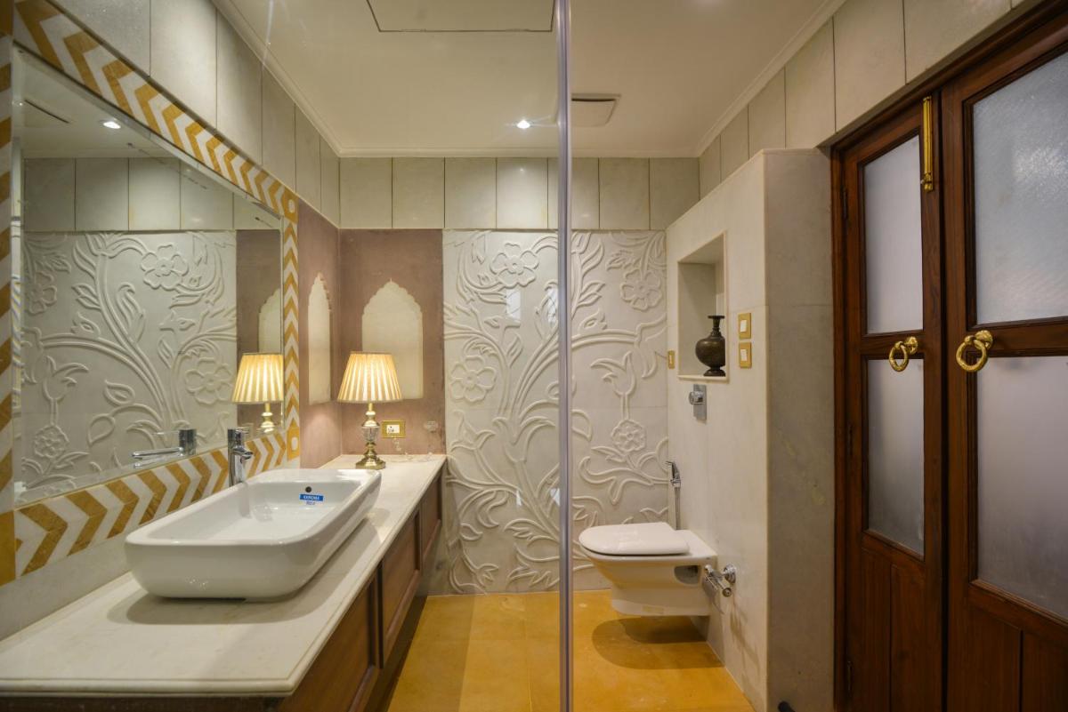 a bathroom with a sink and a toilet and a shower at Haveli Dharampura & Golden Haveli- UNESCO awarded Boutique Heritage Hotel in New Delhi a bathroom with a sink and a toilet and a shower at Haveli Dharampura & Golden Haveli- UNESCO awarded Boutique Heritage Hotel in New Delhi