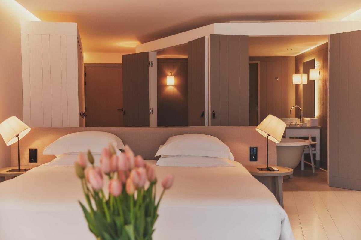 une chambre d'hôtel avec deux lits et des fleurs sur le lit dans l'établissement Hôtel Plage Palace & Spa, à Palavas-les-Flots