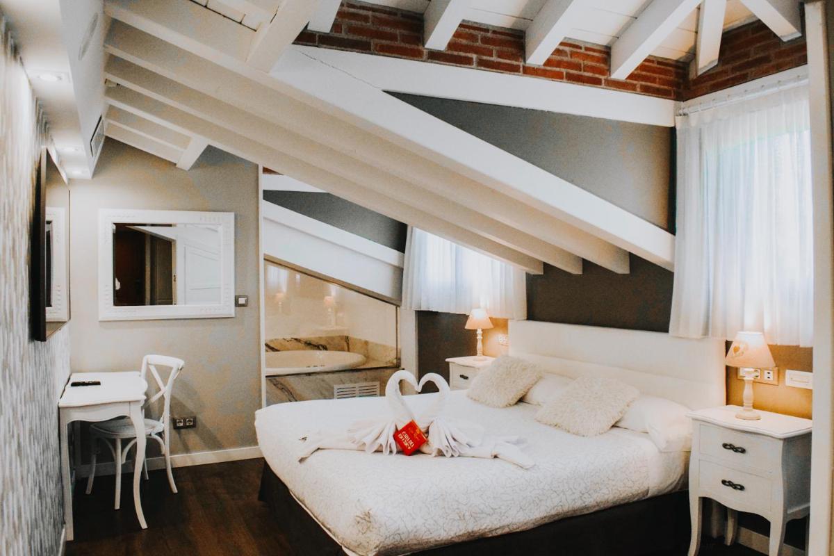 Un dormitorio con una gran cama blanca y un escritorio. en Hotel Spa San Marcos, en Santillana del Mar 39 fotos más
