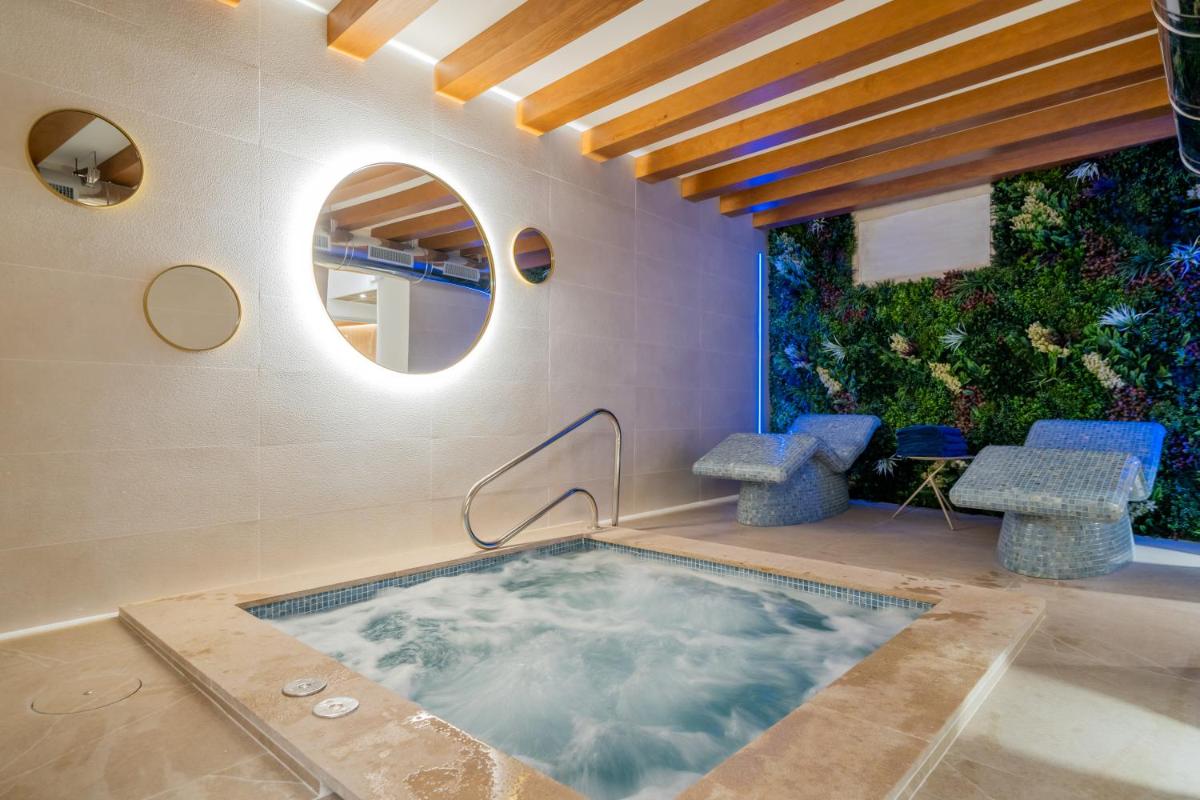 jacuzzi en una habitación con espejo en Santa Clara Urban Hotel & Spa, en Palma de Mallorca