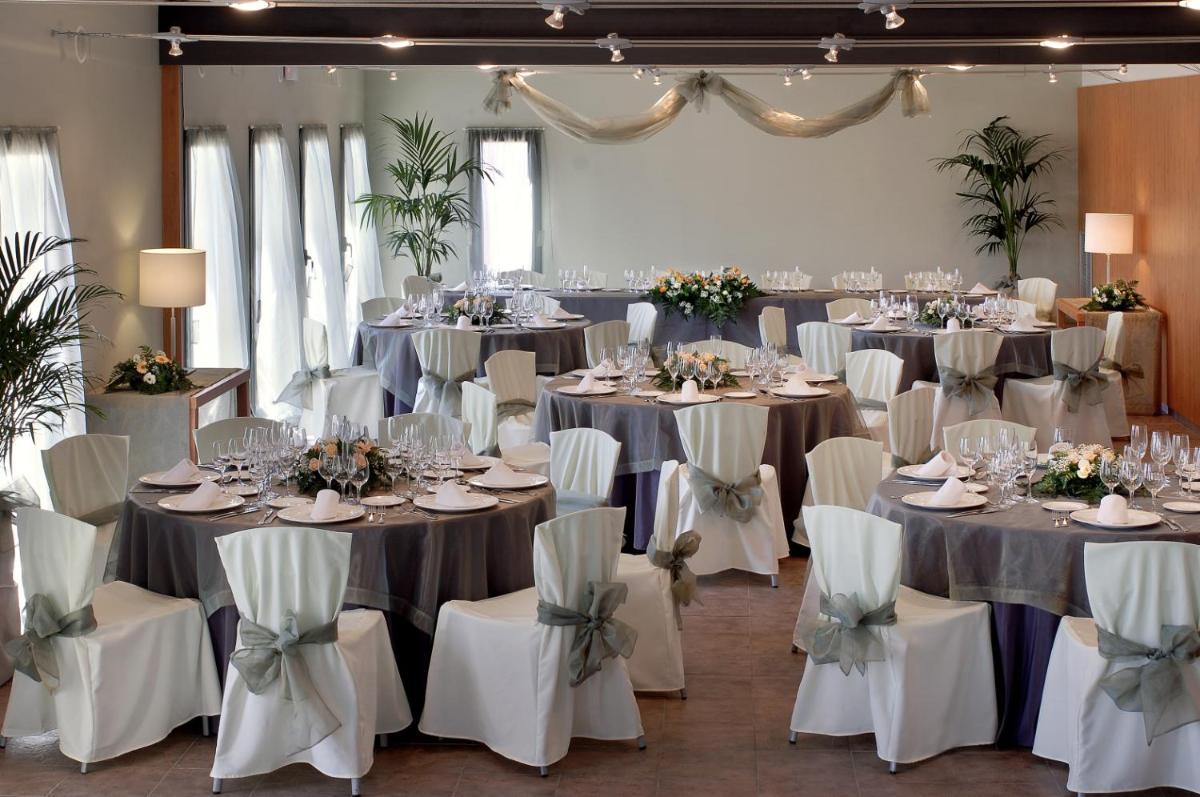 un salón de banquetes con mesas y sillas con platos y copas de vino en Vilar Rural De Sant Hilari Sacalm by Serhs Hotels, en Sant Hilari Sacalm 105 fotos más