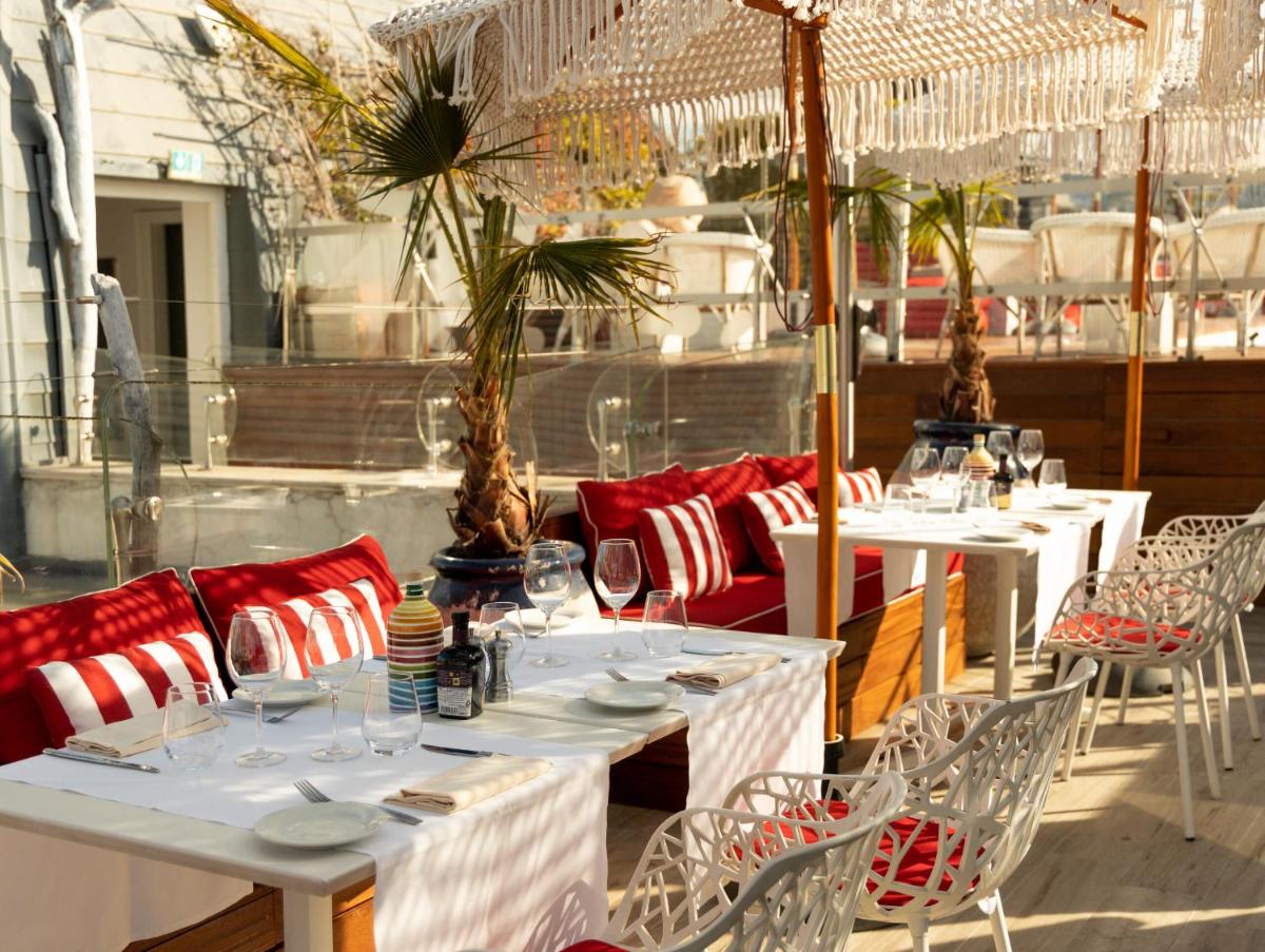 une rangée de tables et de chaises dans un restaurant dans l'établissement Boscolo Nice Hotel & Spa, à Nice