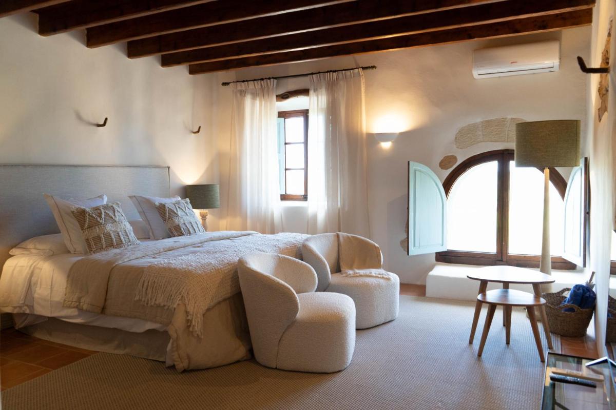 Un dormitorio con una cama grande y una silla. en Reserva Rotana Golf Resort, en Manacor