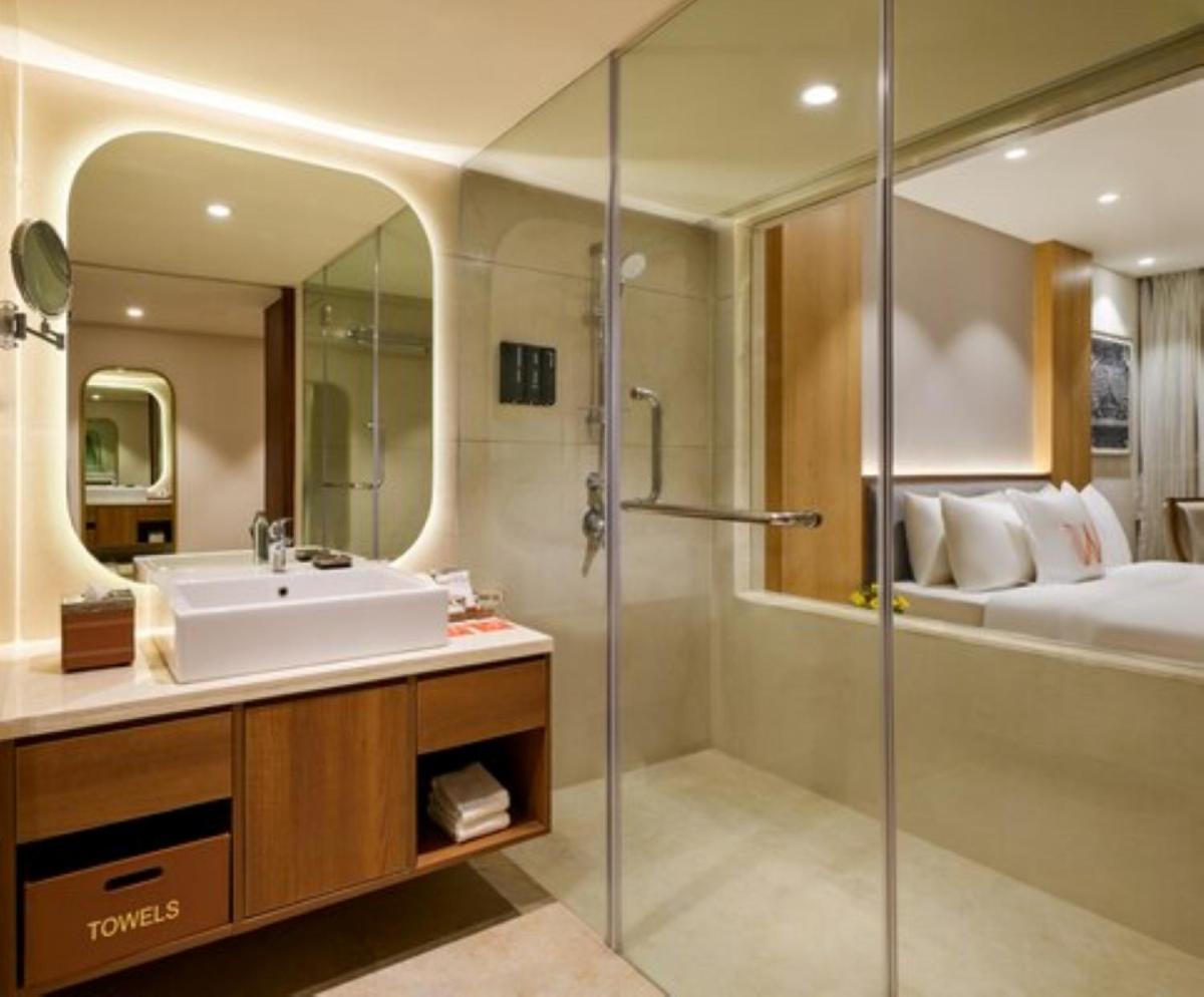 a bathroom with a sink and a shower and a bed at Welcomhotel by ITC Hotels, Ashram Road, Ahmedabad in Ahmedabad