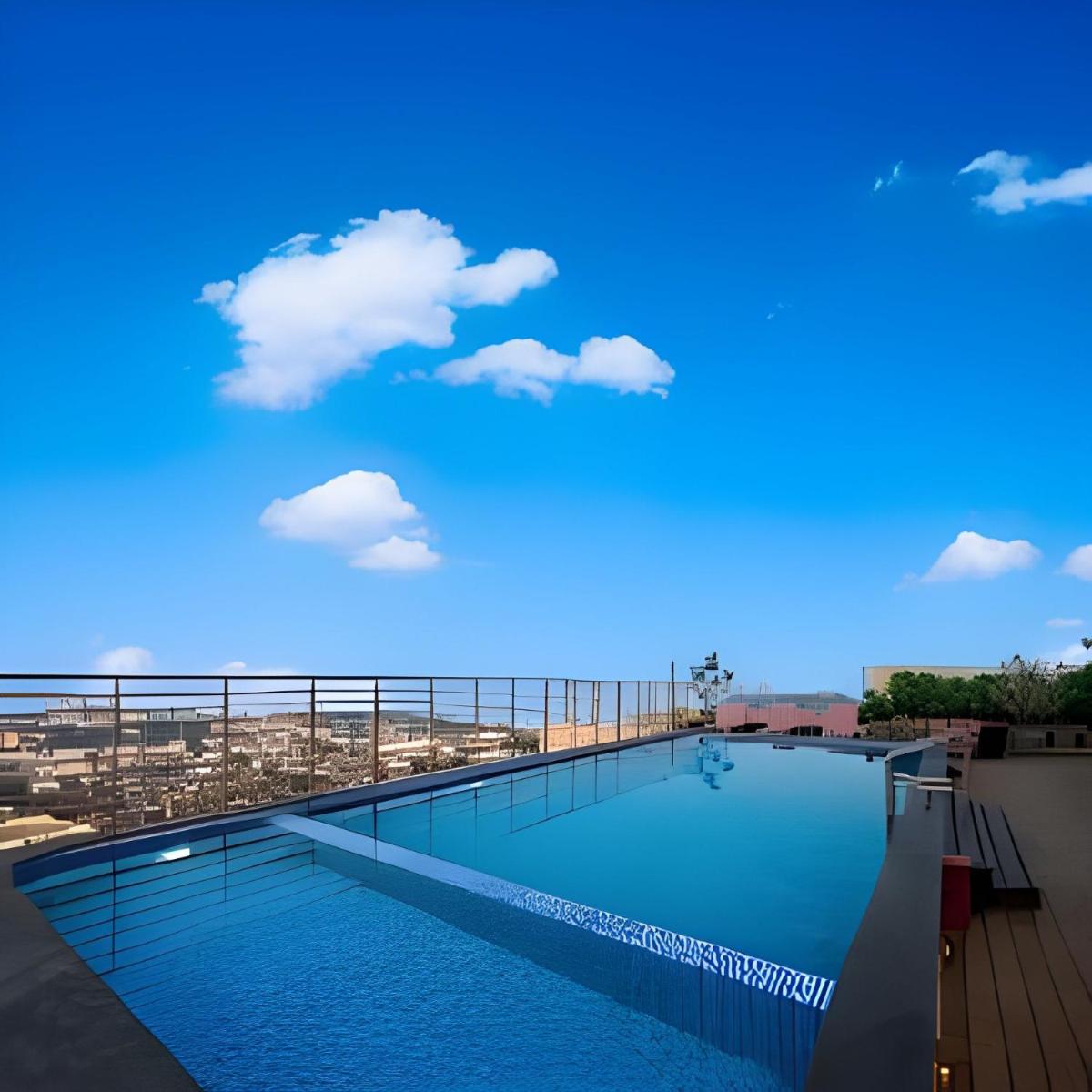 a swimming pool on top of a building with a blue sky at Welcomhotel by ITC Hotels, Ashram Road, Ahmedabad in Ahmedabad