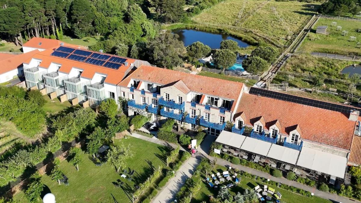 Vue aérienne d'une grande maison avec un lac dans l'établissement Eco-Domaine La Fontaine - HOTEL-SPA - 300 m Plage de la Fontaine aux Bretons, à Pornic