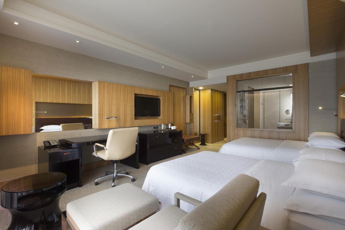 a hotel room with two beds and a desk at Sheraton Grand Bangalore Hotel at Brigade Gateway in Bengaluru