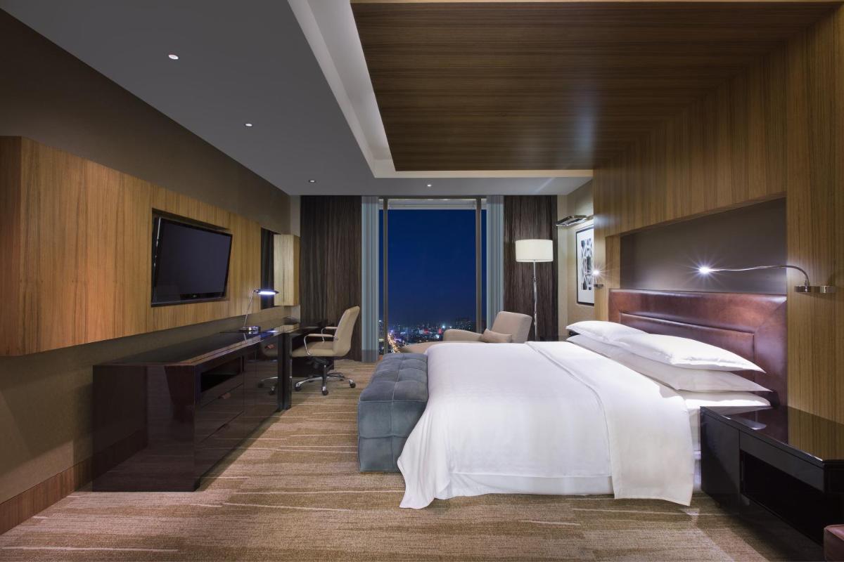 a hotel room with a large bed and a desk at Sheraton Grand Bangalore Hotel at Brigade Gateway in Bengaluru