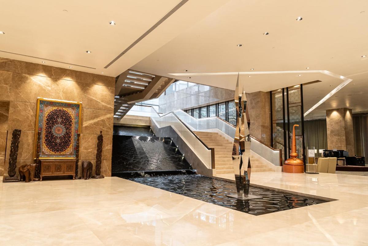 a lobby of a building with a fountain and stairs at Sheraton Grand Bangalore Hotel at Brigade Gateway in Bengaluru