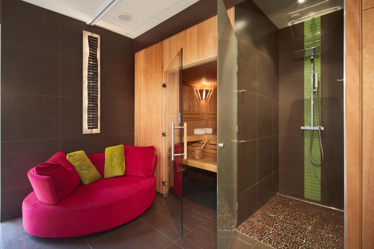 un canapé rose dans une salle de bain avec douche dans l'établissement Campanile Roissy - Aéroport CDG - Le Mesnil Amelot, au Mesnil-Amelot