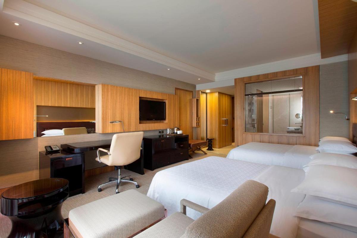 a hotel room with two beds and a desk at Sheraton Grand Bangalore Hotel at Brigade Gateway in Bengaluru
