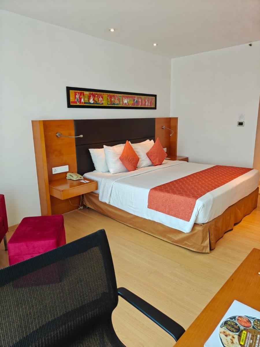 a bedroom with a large bed and a table at Mercure Hyderabad KCP Banjara Hills, An Accor Hotel in Hyderabad