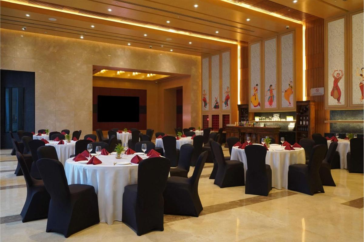a banquet hall with white tables and black chairs at Radisson Blu Hotel Amritsar in Amritsar