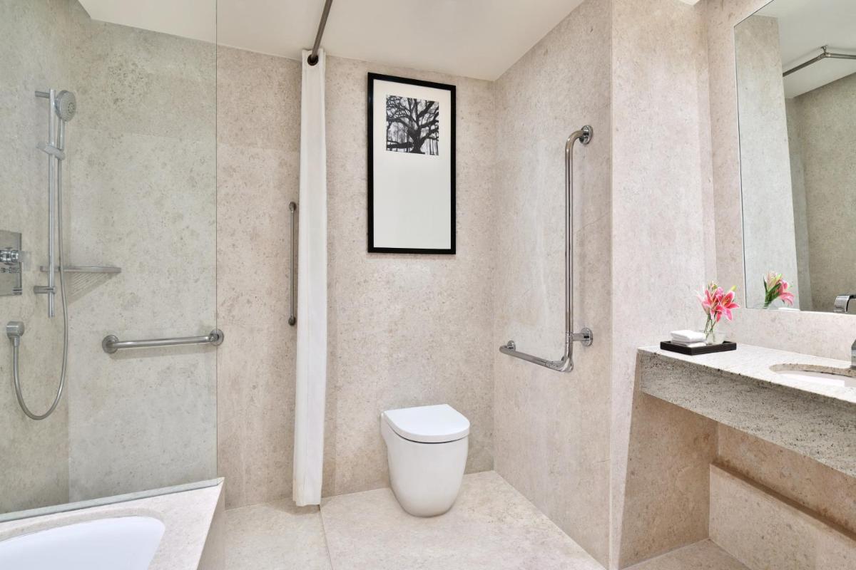 a bathroom with a shower and a toilet and a sink at Sheraton Grand Bangalore Hotel at Brigade Gateway in Bengaluru