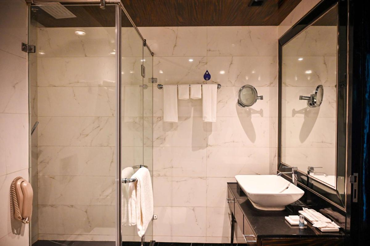 a bathroom with a shower and a sink at Radisson Blu Hotel New Delhi Paschim Vihar in New Delhi a bathroom with a shower and a sink at Radisson Blu Hotel New Delhi Paschim Vihar in New Delhi