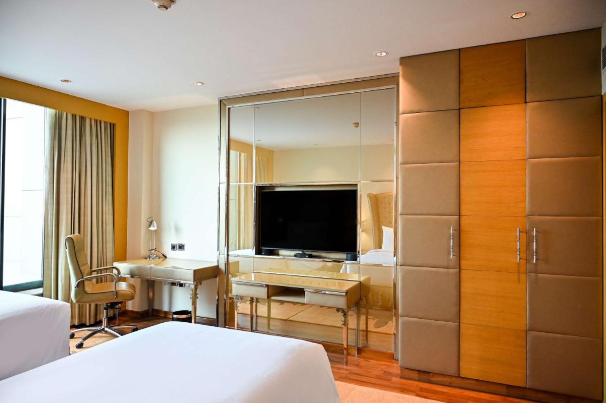a hotel room with a television and a bedroom at Radisson Blu Hotel New Delhi Paschim Vihar in New Delhi a hotel room with a television and a bedroom at Radisson Blu Hotel New Delhi Paschim Vihar in New Delhi