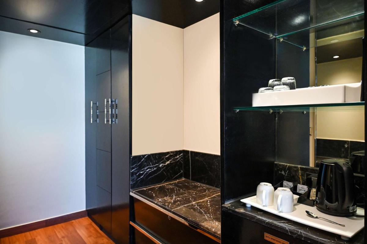 a black bathroom with a sink and a shower at Radisson Blu Hotel New Delhi Paschim Vihar in New Delhi