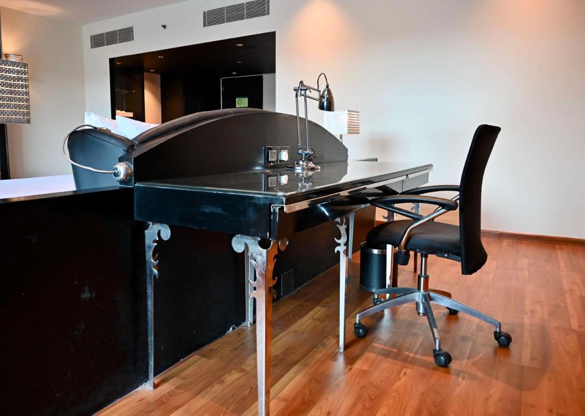 a black desk with a chair and a mirror at Radisson Blu Hotel New Delhi Paschim Vihar in New Delhi a black desk with a chair and a mirror at Radisson Blu Hotel New Delhi Paschim Vihar in New Delhi