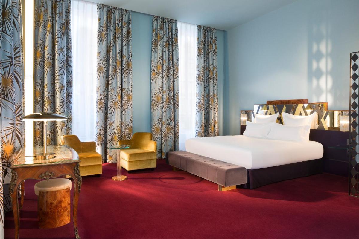 une chambre d'hôtel avec un lit et une chaise dans l'établissement Hôtel Saint-Marc, à Paris