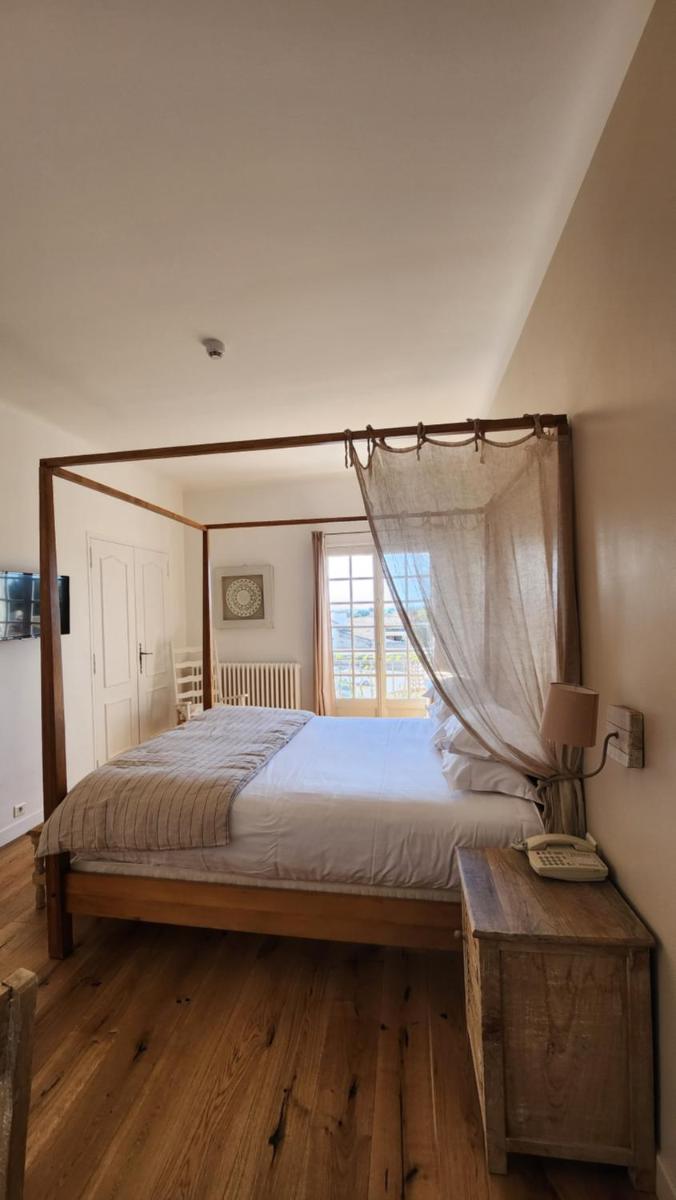 une chambre avec un grand lit et une fenêtre dans l'établissement La Regalido, à Fontvieille