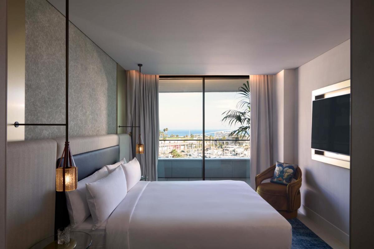 Una habitación de hotel con una cama y una ventana grande. en SLS Barcelona, en Barcelona