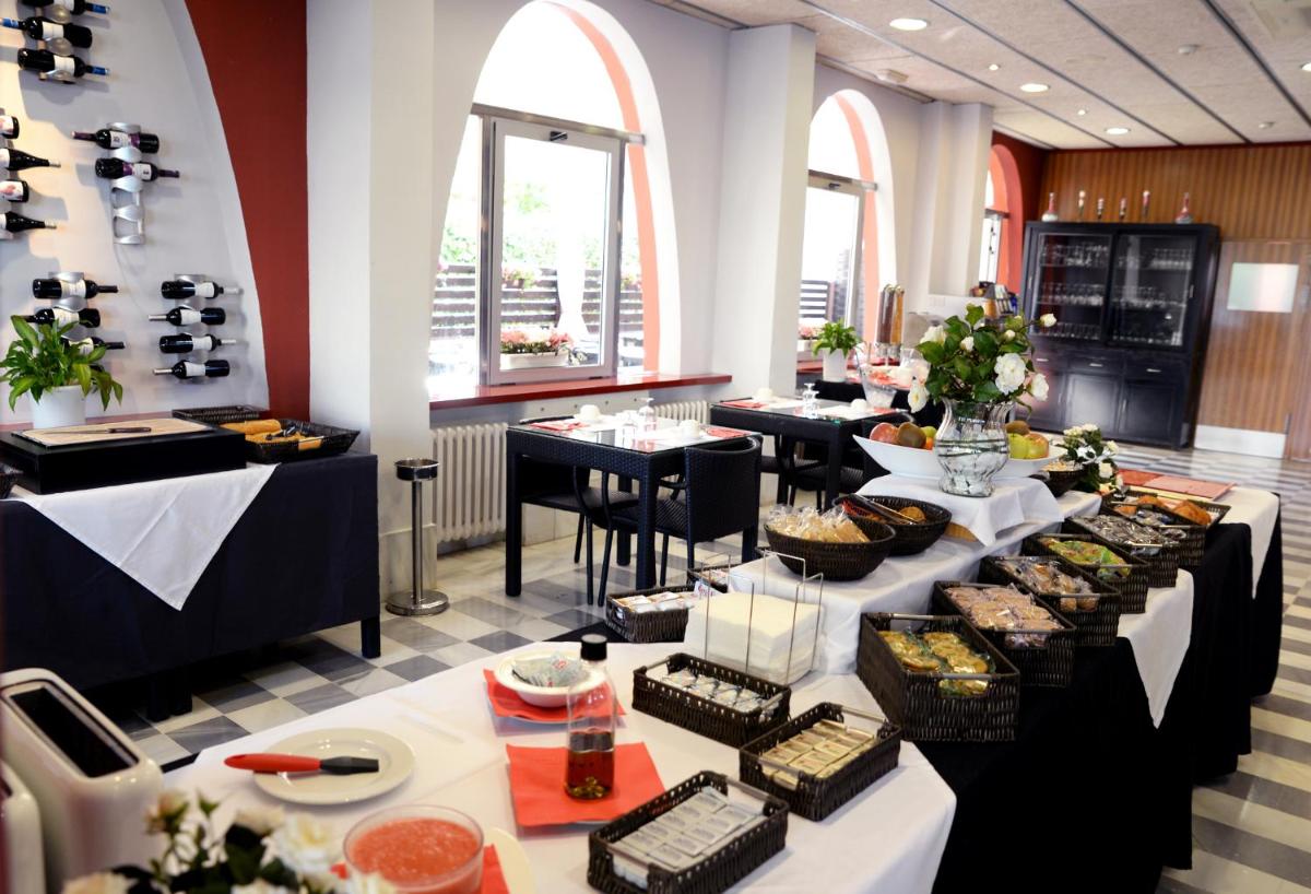 un restaurante con mesas con comida. en Hotel Spa Pinar del Mar, en Platja d'Aro