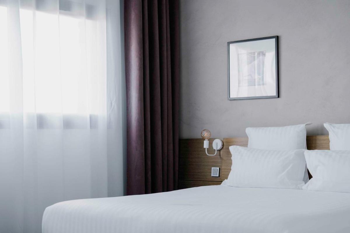 Un ou plusieurs lits dans un hébergement de l'établissement Best Western Hôtel De La Cité & Spa