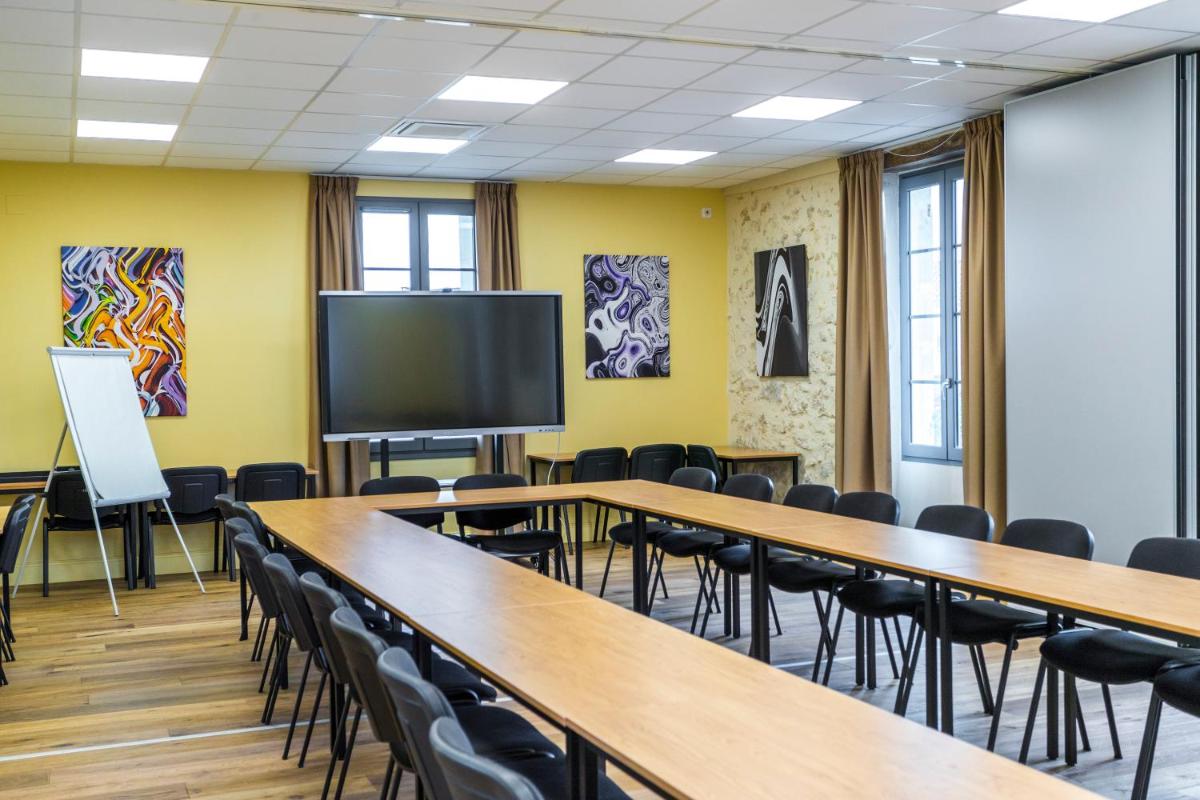 d'une salle de conférence avec des tables et des chaises et une télévision à écran plat. dans l'établissement Hotel Clos Castel Villas Spa, à Casteljaloux