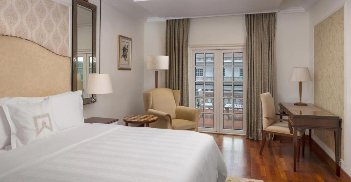 a hotel room with a bed and a desk and a window at ITC Windsor, a Luxury Collection Hotel, Bengaluru in Bengaluru a hotel room with a bed and a desk and a window at ITC Windsor, a Luxury Collection Hotel, Bengaluru in Bengaluru