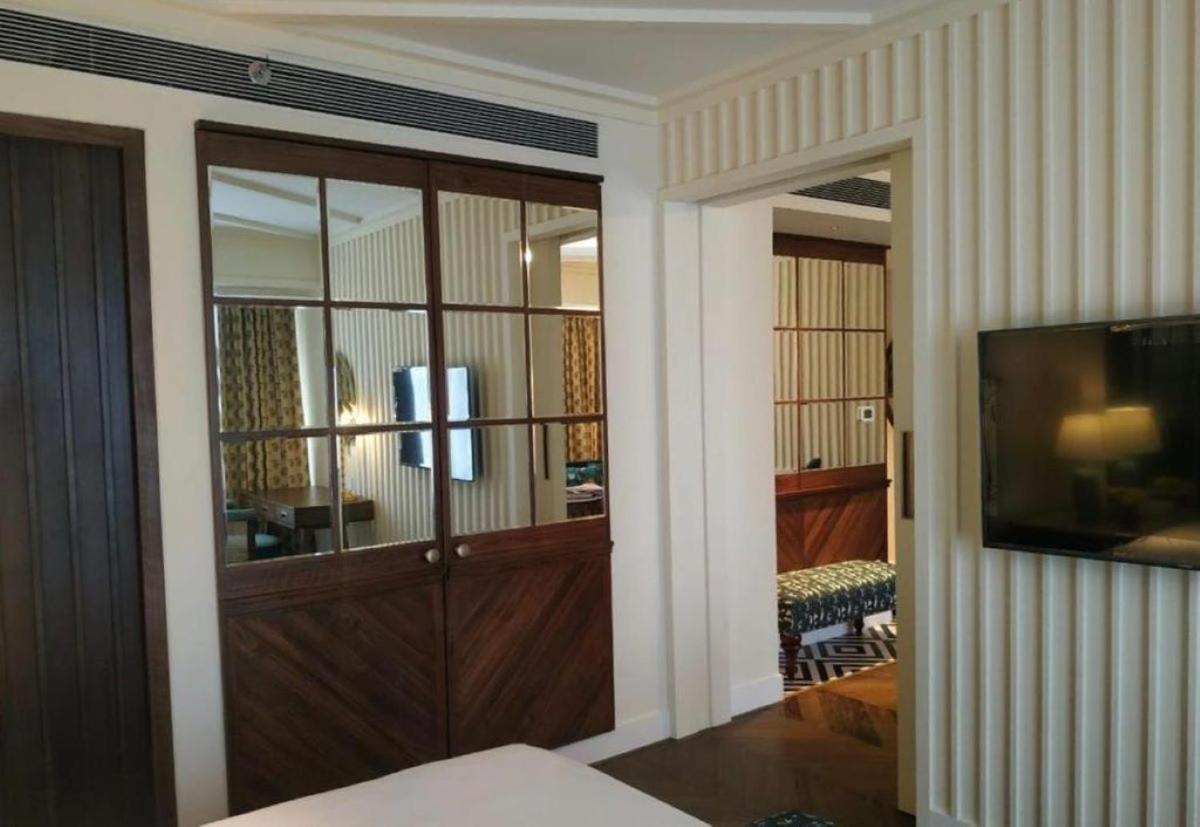 a room with a large wooden door with a television at Blue Diamond Pune IHCL SeleQtions in Pune