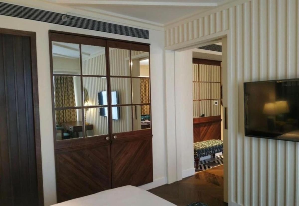 a room with a large wooden door with a television at Blue Diamond Pune IHCL SeleQtions in Pune