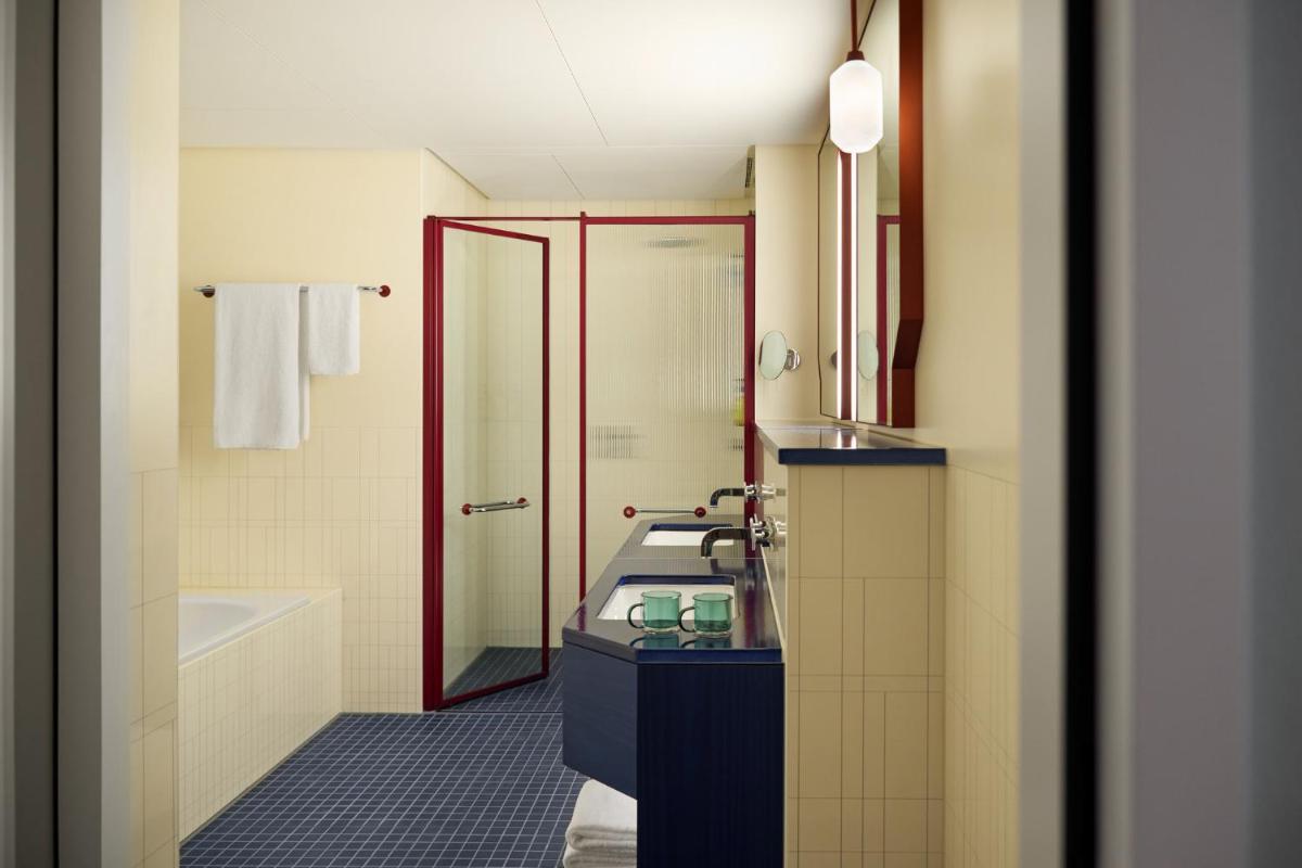 ein Badezimmer mit Waschbecken und Badewanne in der Unterkunft Kimpton Main Frankfurt by IHG in Frankfurt am Main