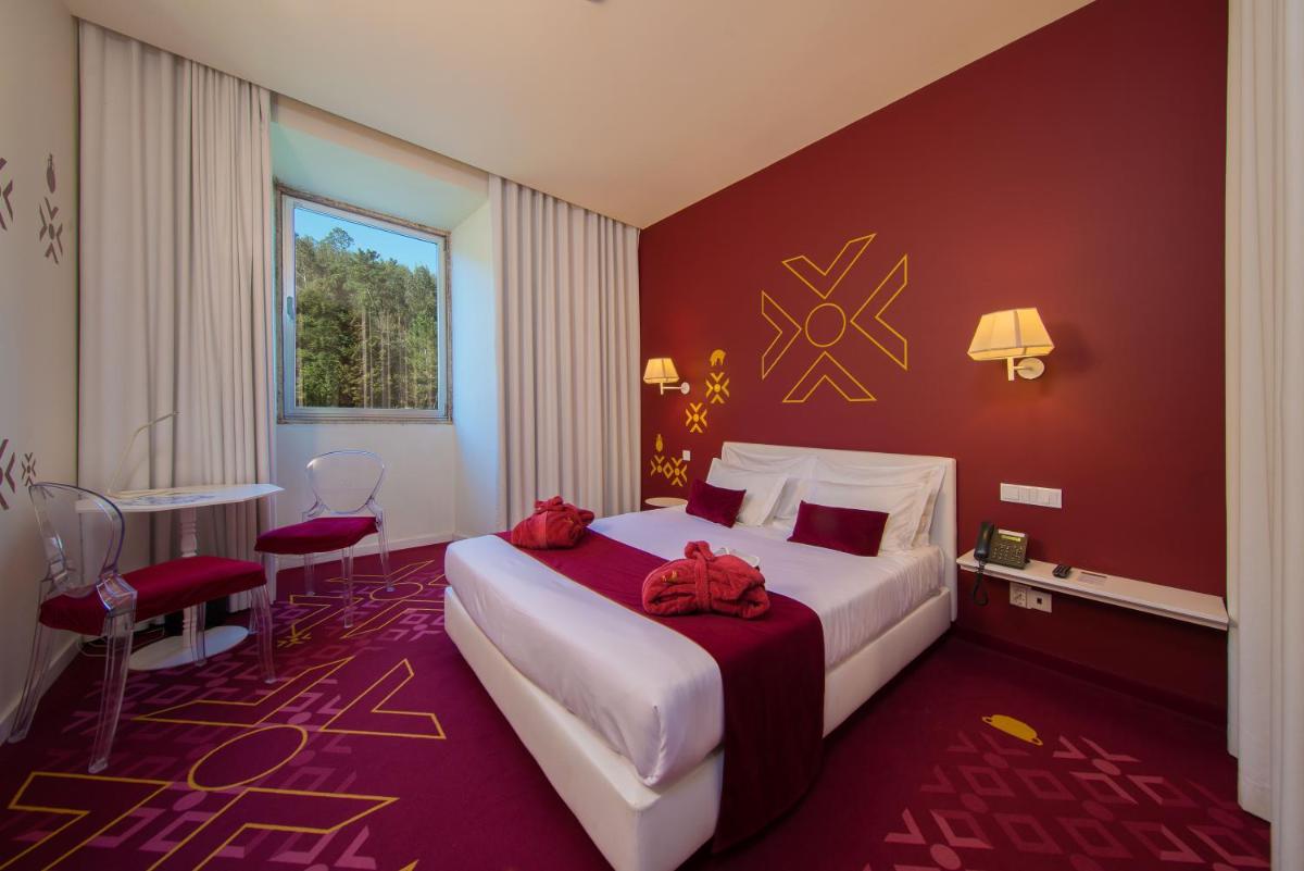 um quarto com uma cama grande e uma parede vermelha em HD