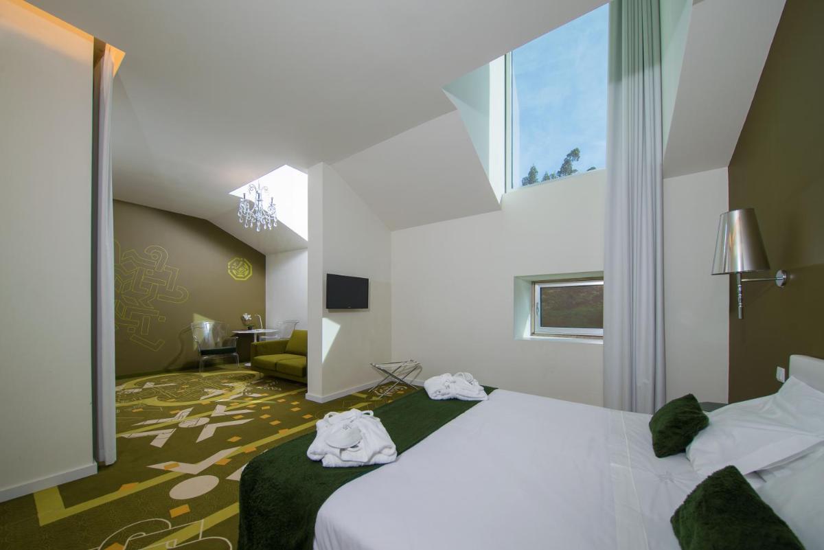 um quarto de hotel com uma cama e uma sala de estar em HD